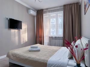 ein Schlafzimmer mit einem Bett mit zwei Handtüchern darauf in der Unterkunft Просторная квартира для большой компании in Almaty