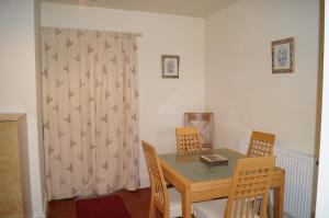 a dining room with a table and chairs and a curtain at 2 Buckatree Cottage in Wellington