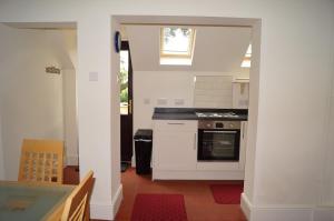 a kitchen with a stove and an open doorway at 2 Buckatree Cottage in Wellington +23 photos