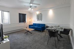 a living room with a blue couch and a table at 2-bedroom- Stoke-on-Trent-Sleeps 5-PetsOk in Stoke on Trent