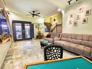 Una sala de estar con un sofá y una mesa de billar. en IPOH Taman Pelangi Double Storey Homestay, en Ipoh