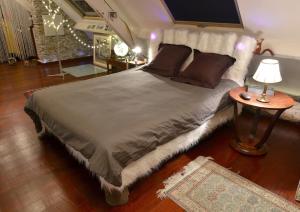 ein Schlafzimmer mit einem großen Bett und einem Tisch in der Unterkunft Le Loft de l'artiste in Nantes