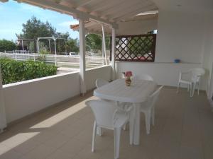 un tavolo bianco e sedie su un balcone di 3 Bedroom House, 200m from Trikorfo Beach a Yerakiní