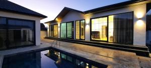 a house with a swimming pool in front of it at White villas in Qusar