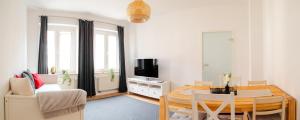 a living room with a table and a television at Ruhige Wohnung auf dem Sonnenstein in Pirna