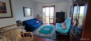 a living room with blue couches and a tv at Casa vacanze Mare Monti in Grottammare