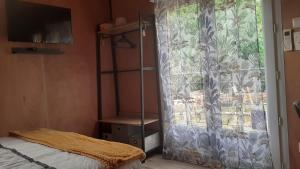 a bedroom with a bed and a window with a curtain at le Clos des Golferies, chalet avec jacuzzi in Les Mothes