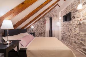 ein Schlafzimmer mit einem Bett und einer Steinwand in der Unterkunft ZUZORI apartments in Dubrovnik