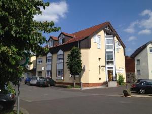 a building with cars parked in a parking lot at 2x Einzelbetten - Gästezimmer - 11min von Gießen Zentrum 8,4km in Fernwald in Steinbach