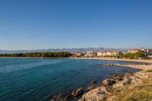 a view of a beach with people on the shore at apartments VIGI - III in Povljana +9 photos