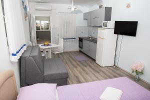 a small living room with a couch and a kitchen at apartments VIGI - III in Povljana