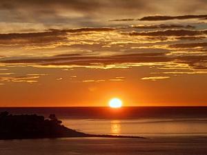 a sunset over the ocean with the sun setting at A 50 metros del mar y en 2 paradas de bus estas en el centro de Alicante in Alicante +24 photos