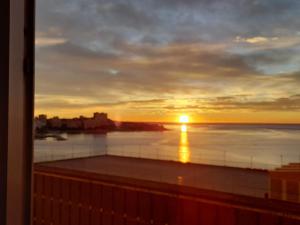 a sunset from the balcony of a building at A 50 metros del mar y en 2 paradas de bus estas en el centro de Alicante in Alicante
