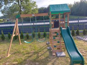 a playground with a slide and a swing at Dom Nad Potokiem Średnia Wieś in Hoczew
