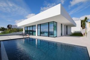 a house with a swimming pool in front of it at Ocean Pearl - Deluxe OceanView Heated Pool in Vila Franca do Campo