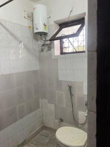 une salle de bain avec toilettes et fenêtre dans l'établissement White House shikargarah Jodhpur, à Jodhpur 4 autres photos