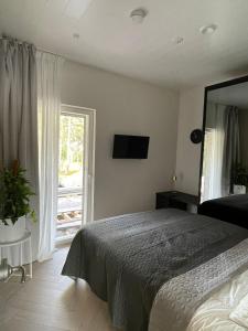 Un dormitorio con una cama y una ventana grande. en Forest Dream House, en Naantali