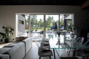 a living room with a glass table and chairs at Forest Dream House in Naantali