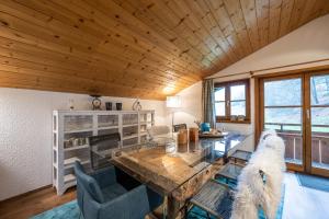 a living room with a wooden ceiling and a table and chairs at Ferienwohnung Lichtblick in Oberstdorf