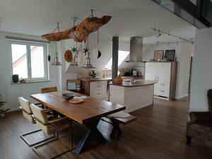 a kitchen with a wooden table and a dining room at Dorfliebe Reicherstein in Pöttmes