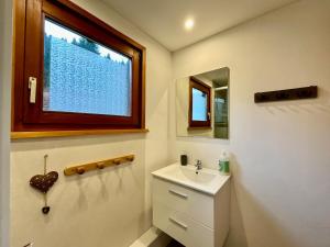 une salle de bain avec un lavabo et une fenêtre dans l'établissement Chalet Les 3 Lueurs, authentique au pied de pistes, à Xonrupt-Longemer 10 autres photos