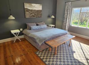 a bedroom with a large bed and a rug at Môreson Cottage in Klaarstroom