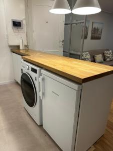 a kitchen with a washer and dryer under a counter at Alojamientos Castellana Jardín 1 y 2 PARKING Y PISCINA GRATIS!! in Burgos