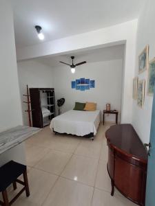 a bedroom with a bed and a desk in it at Vereda da Lagoa in Niterói