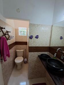 a bathroom with a toilet and a black sink at Vereda da Lagoa in Niterói