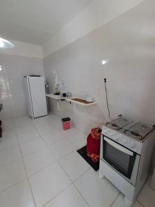 a white kitchen with a stove and a refrigerator at Vereda da Lagoa in Niterói +7 photos