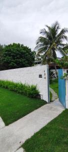 a white building with a palm tree next to a driveway at Vereda da Lagoa in Niterói