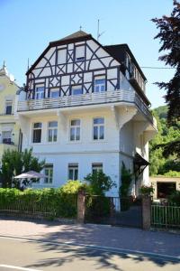 a large white building with a black and white roof at Villa Rheinblick 1 OG in Kamp-Bornhofen