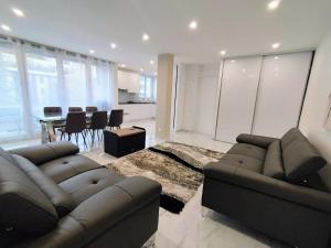 a living room with two couches and a dining room at L'Exclusif Paris Neuilly Levallois in Levallois-Perret