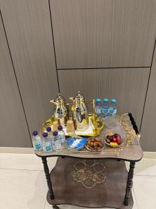 a table with a tray of food and water bottles at سكناي بارك للشقق المخدومة in Arar