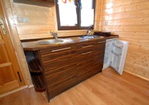 eine kleine Küche mit Spüle und Fenster in der Unterkunft Domki Letniskowe Wydma in Bobolin + 34 Fotos