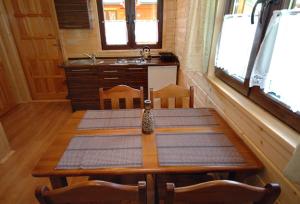 ein Holztisch in einem Raum mit Küche in der Unterkunft Domki Letniskowe Wydma in Bobolin