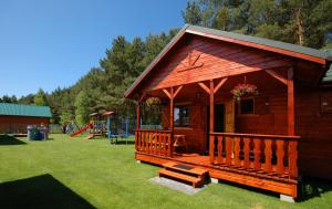 eine kleine Hütte mit Bank und Spielplatz in der Unterkunft Domki Letniskowe Wydma in Bobolin