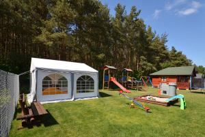 einen Hinterhof mit einem Spielplatz mit Zelt und Rutsche in der Unterkunft Domki Letniskowe Wydma in Bobolin