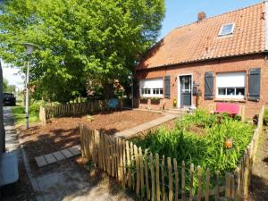 a fence in front of a house with a yard at Huus an`t Dörpsdiek in Krummhörn