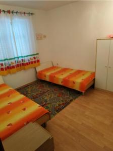 a small room with two beds and a window at Apartment Zaglav 3 - first sea row in Zaglav