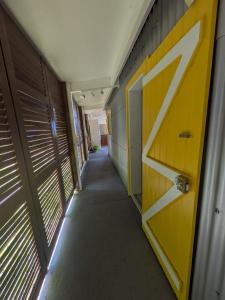 an empty hallway with a yellow door in a building at Case Octave, le charme créole entre plage et campagne in Saint-Leu