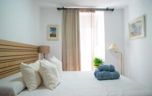 a bedroom with a white bed with a large window at Casa Hera - Boutique House in Alhaurín el Grande in Alhaurín el Grande