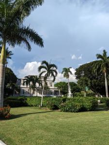 a white house with palm trees in a park at BridgeView Arcadia One in Portmore