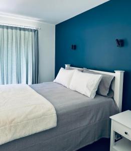 a blue bedroom with a bed and a window at Athol Country Bed and Breakfast in Athol