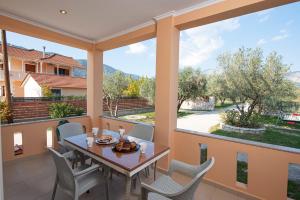 a dining room with a table and chairs on a balcony at Villa Agrilida in Vasiliki