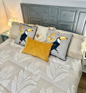 a bed with three pillows on top of it at In Love Zamora in Zamora