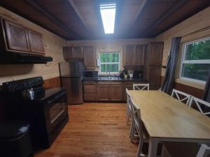 a kitchen with wooden cabinets and a wooden table with a wooden floor at Mountainside Cabin, Secluded, Hot Tub, Lake Accessible in Rockbridge +14 photos