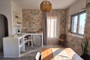 a kitchen with a brick wall and a table at Akallis Villa in Galini