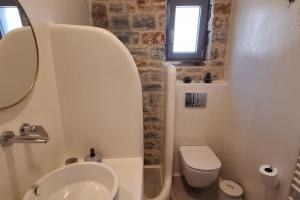 a bathroom with a sink and a toilet and a window at Akallis Villa in Galini