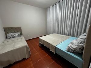 a bedroom with two beds and a window at Espaço Lara Eventos Igarapé in Igarapé +43 photos